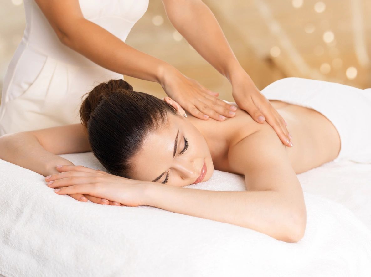A woman getting her back touched by a masseuse.